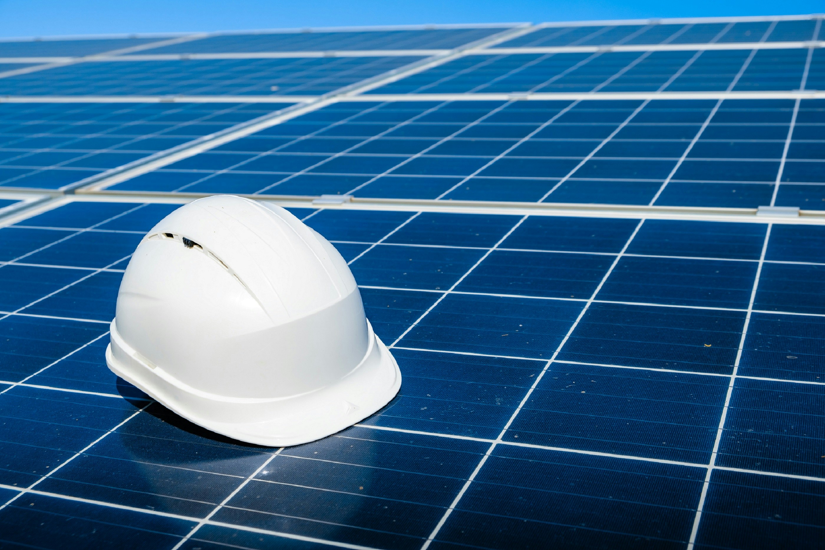 Hard hat on solar panels — energy audit